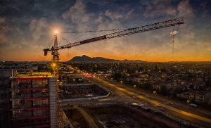 Aerial of crane looking over road and building sunset